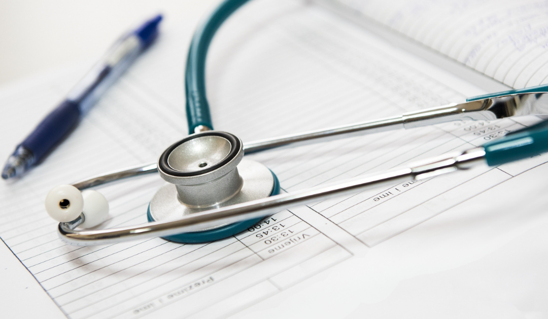 Foto con strumento misuratore battiti cardiaci e respiro medico nutrizionista e quaderno per appuntare i risultati.