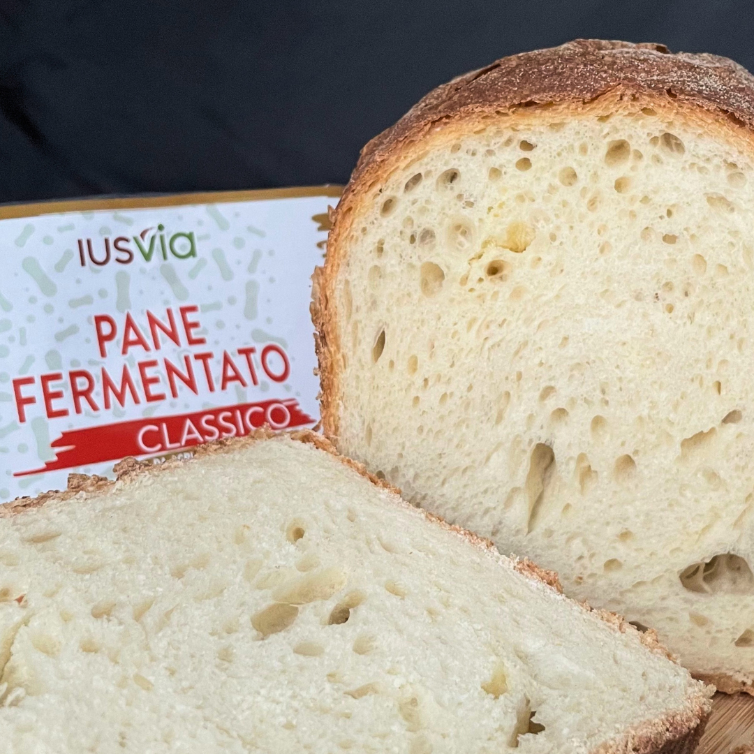 Foto prodotto Pane Fermentato Classico da Agricoltura Biologica. Si vede il pane tagliato a fette. E sullo sfondo l'etichetta del prodotto.